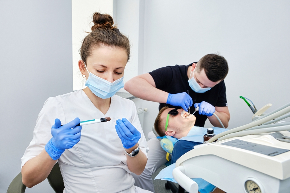 Dentist,And,Assistant,Cementing,Crown.,Installing,A,Dental,Crown.,Teamwork